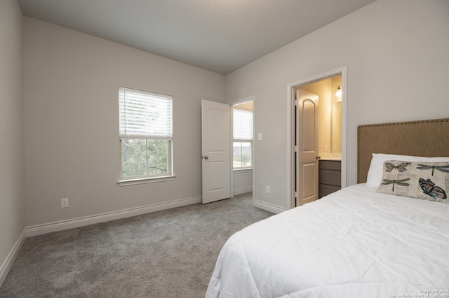 carpeted bedroom featuring ensuite bath