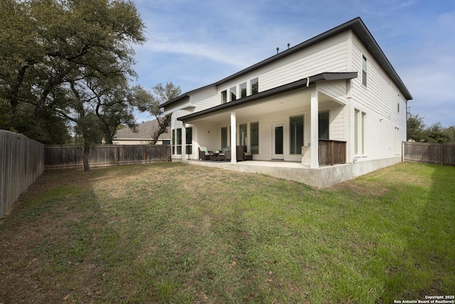 back of house featuring a patio area and a lawn