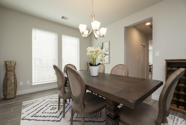 dining area featuring dark hardwood / wood-style floors and an inviting chandelier