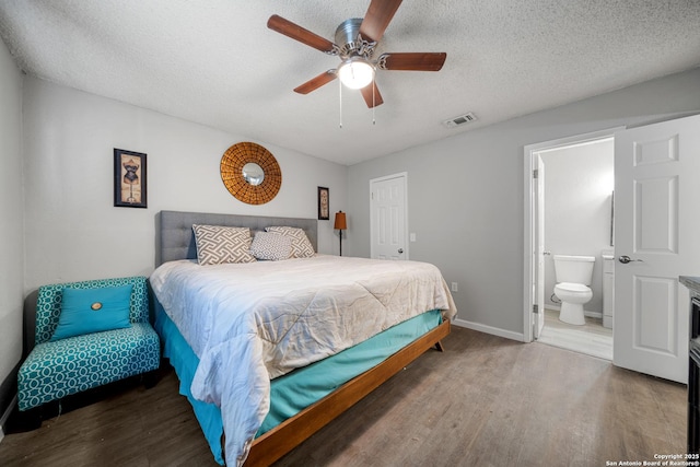 bedroom with wood-type flooring, ensuite bathroom, and a textured ceiling