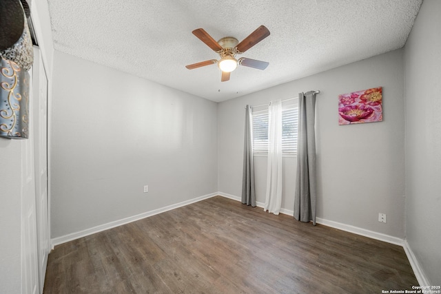 empty room featuring dark hardwood / wood-style floors, a textured ceiling, and ceiling fan