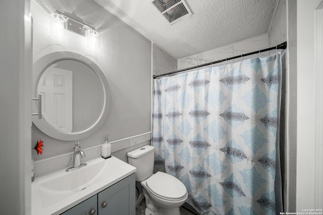 bathroom with vanity, curtained shower, a textured ceiling, and toilet