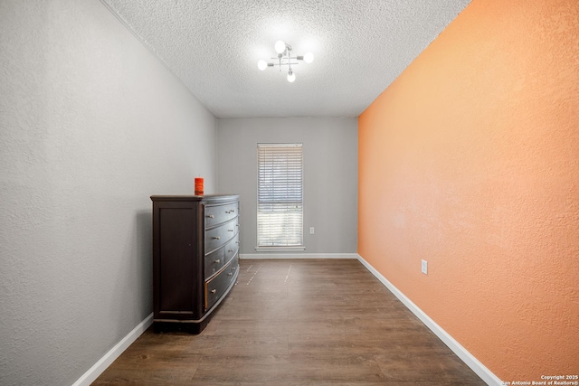 unfurnished room featuring dark hardwood / wood-style floors and a textured ceiling