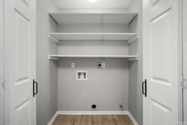 washroom with hardwood / wood-style floors, hookup for a gas dryer, hookup for a washing machine, electric dryer hookup, and a textured ceiling