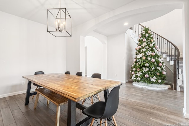 dining space with wood-type flooring and a notable chandelier