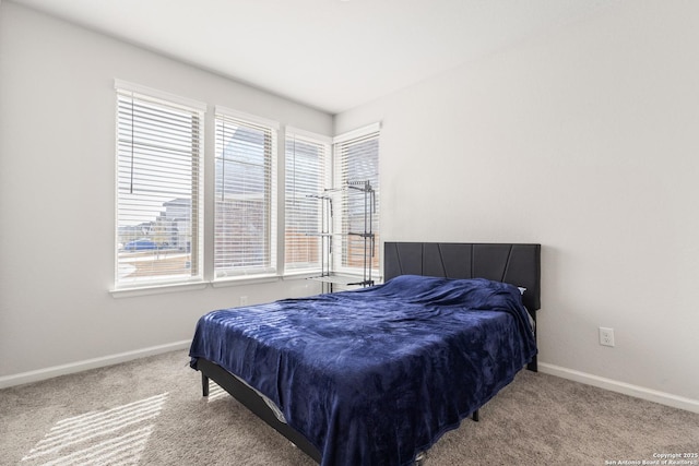 carpeted bedroom featuring multiple windows