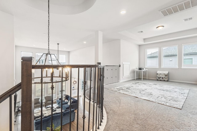 hallway with a chandelier and carpet floors