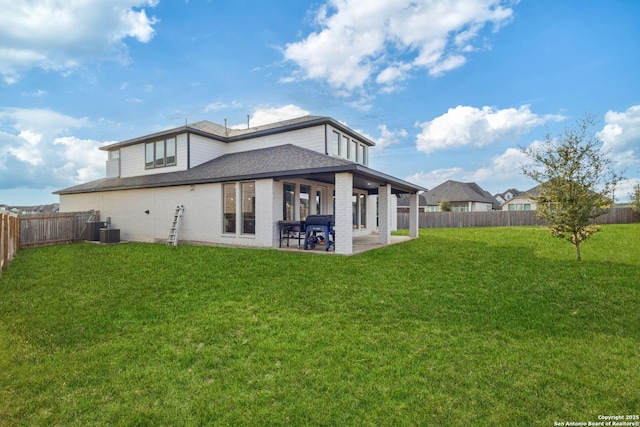 back of house featuring a lawn, a patio, and central air condition unit