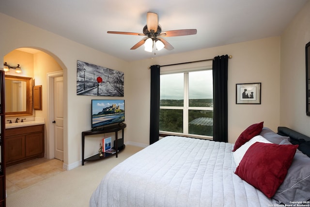 carpeted bedroom with sink, connected bathroom, and ceiling fan