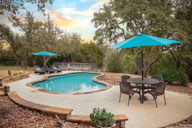 pool at dusk with a patio