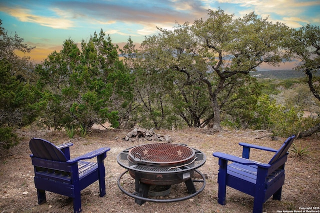 yard at dusk featuring an outdoor fire pit