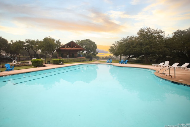 view of pool at dusk