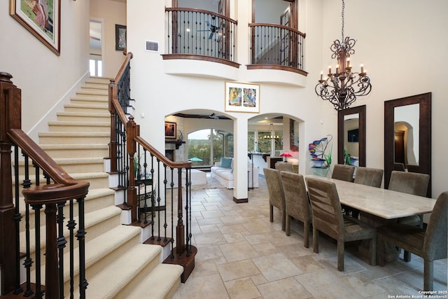 dining space featuring ceiling fan with notable chandelier