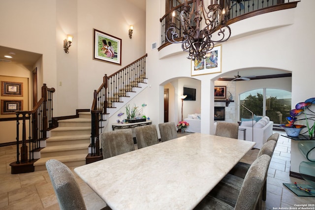 dining space featuring a towering ceiling and ceiling fan