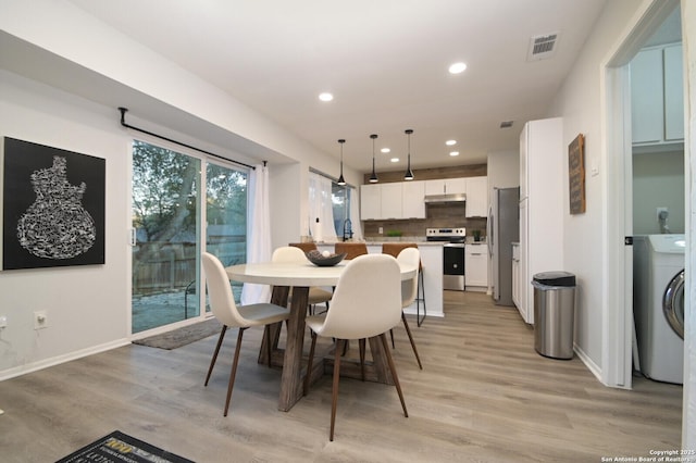 dining space featuring washer / dryer and light hardwood / wood-style flooring