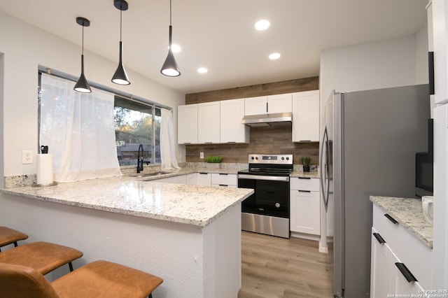 kitchen with stainless steel appliances, sink, pendant lighting, and kitchen peninsula