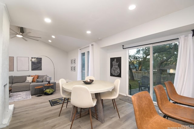 dining space with vaulted ceiling, ceiling fan, and light wood-type flooring