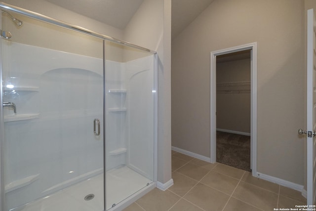 8419 Hamrick Cir, San Antonio, TX 78252 - bathroom featuring a stall shower, tile patterned flooring, a spacious closet, and baseboards