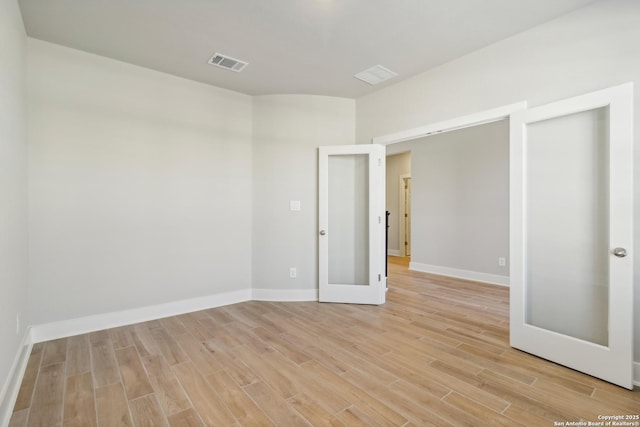 spare room featuring light hardwood / wood-style floors and french doors