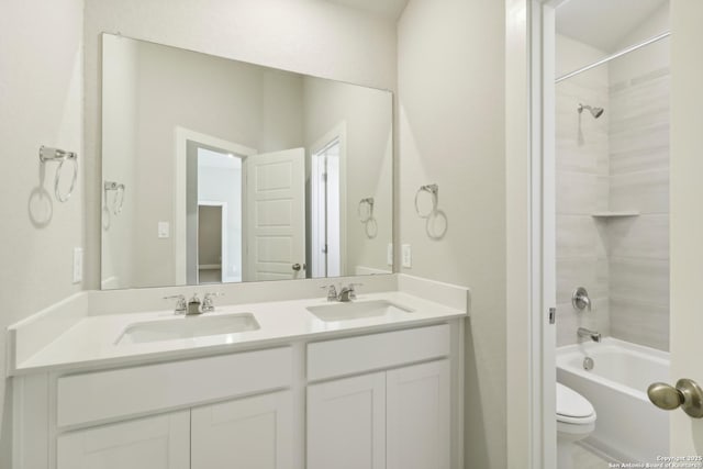 full bathroom featuring vanity, tiled shower / bath combo, and toilet