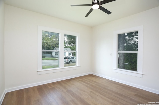 empty room with hardwood / wood-style floors and ceiling fan