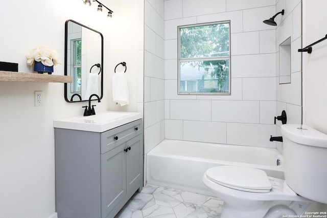 full bathroom featuring tiled shower / bath, vanity, and toilet