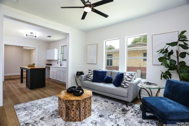 living room featuring ceiling fan, dark hardwood / wood-style flooring, and sink