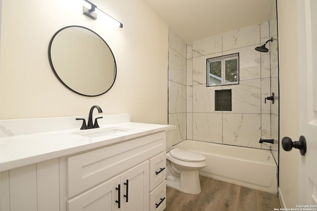 full bathroom with tiled shower / bath, wood-type flooring, toilet, and vanity