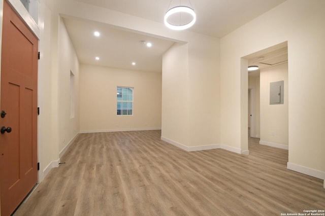 empty room with electric panel and light hardwood / wood-style floors