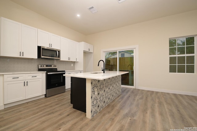 kitchen featuring appliances with stainless steel finishes, a kitchen island with sink, and white cabinets