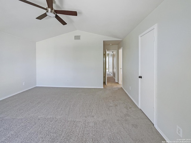 spare room featuring ceiling fan, light colored carpet, and vaulted ceiling