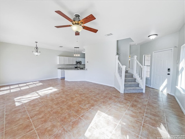 unfurnished living room featuring light tile patterned floors and ceiling fan