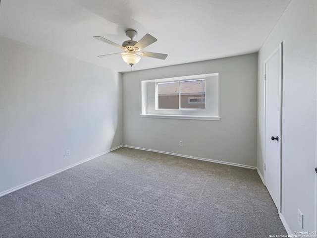 empty room featuring ceiling fan and carpet