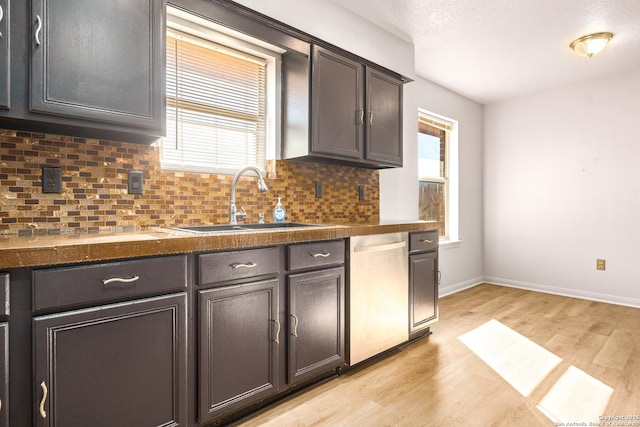 kitchen with sink, dishwasher, backsplash, dark brown cabinets, and light wood-type flooring