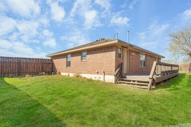 back of property featuring a lawn and a deck