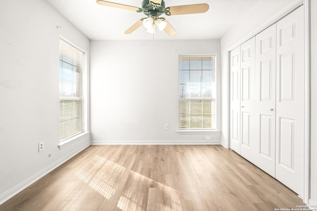 unfurnished bedroom featuring ceiling fan, light wood-type flooring, and a closet