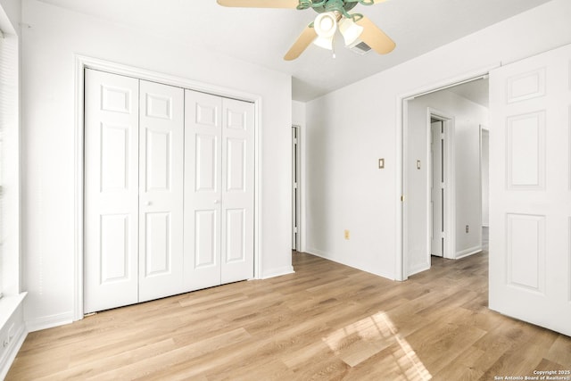 unfurnished bedroom with ceiling fan, light hardwood / wood-style floors, and a closet