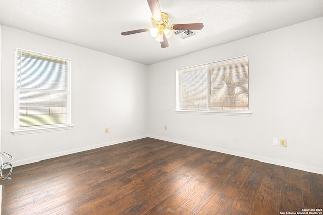 empty room with a textured ceiling, dark wood-type flooring, and ceiling fan