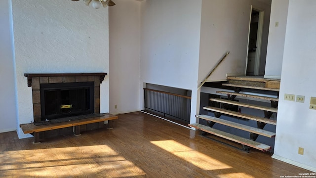 living room featuring dark wood-type flooring and a tile fireplace