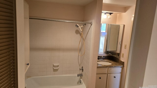 bathroom featuring tiled shower / bath and vanity