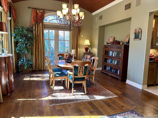 dining area with crown molding, dark wood-type flooring, a chandelier, and vaulted ceiling