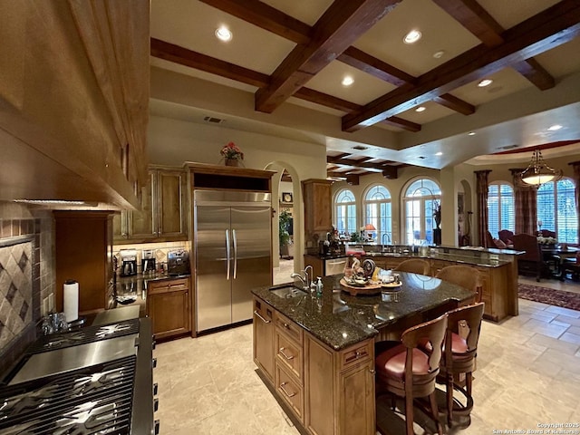 kitchen featuring a large island, sink, stainless steel appliances, a kitchen breakfast bar, and coffered ceiling