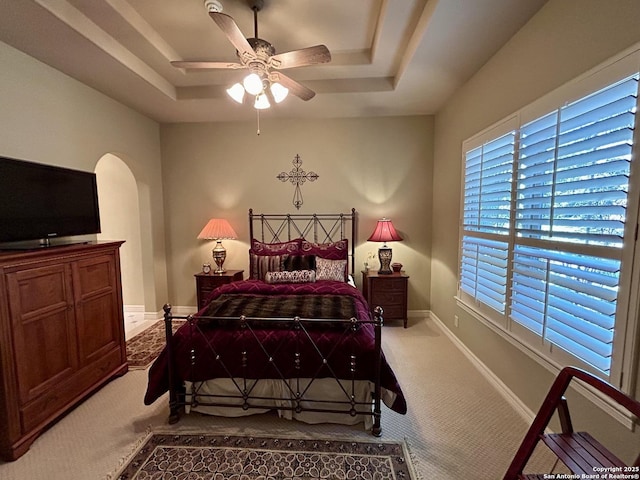 bedroom with ceiling fan, a raised ceiling, and carpet floors