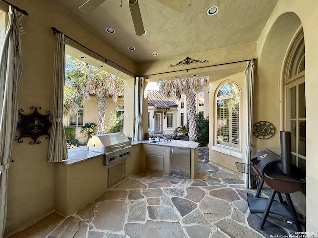 sunroom with ceiling fan and sink