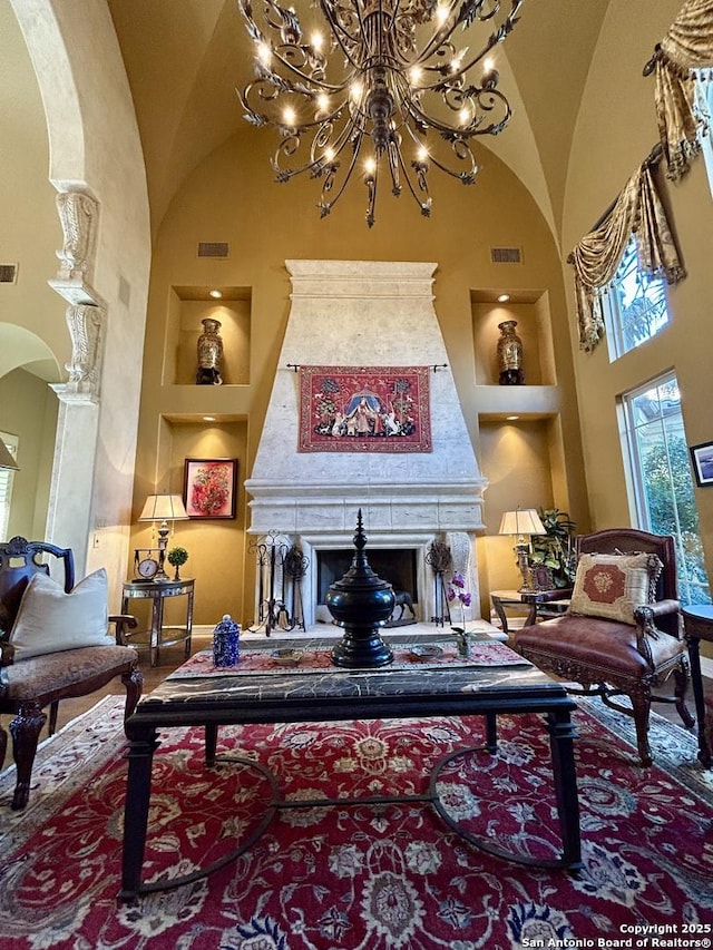 sitting room featuring high vaulted ceiling, built in features, and a premium fireplace