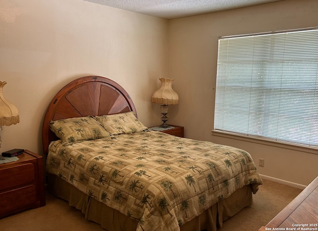 bedroom with light colored carpet and a textured ceiling