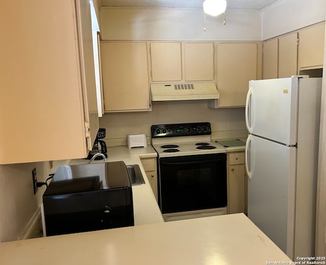 kitchen with white refrigerator, electric range, and cream cabinetry