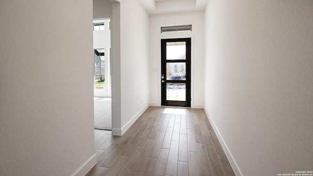 interior space featuring plenty of natural light, baseboards, a high ceiling, and dark wood-type flooring