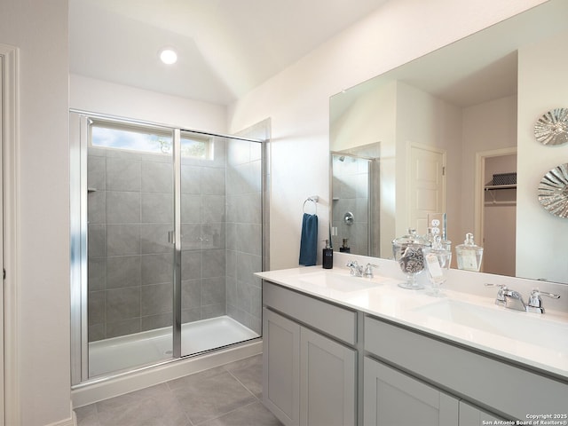 bathroom featuring tile patterned floors, a shower with door, and vanity