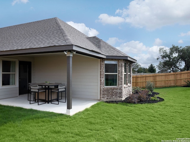 rear view of house featuring a yard and a patio area